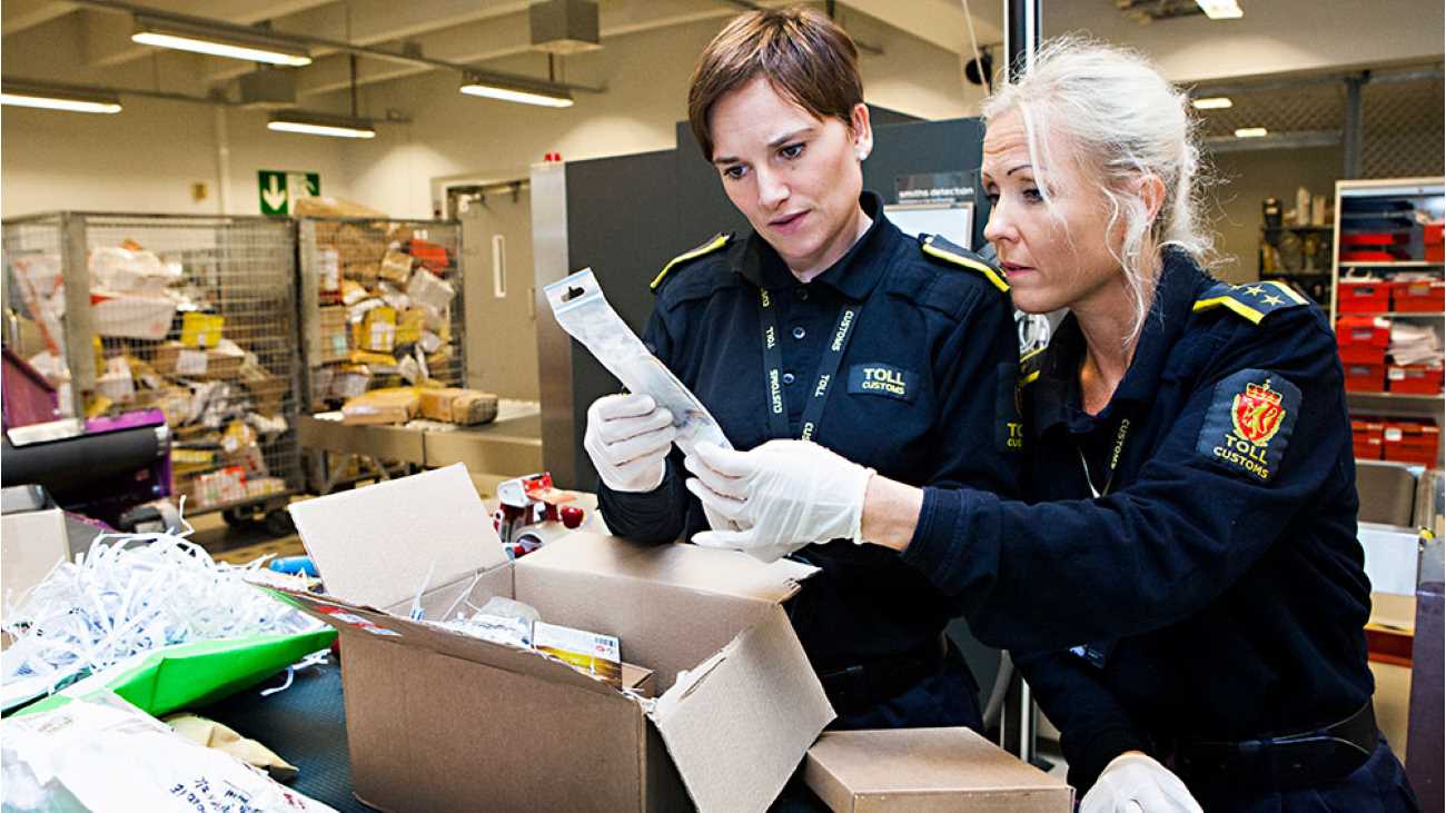 To tollere sjekker innholdet i en pappeske i en postterminal.